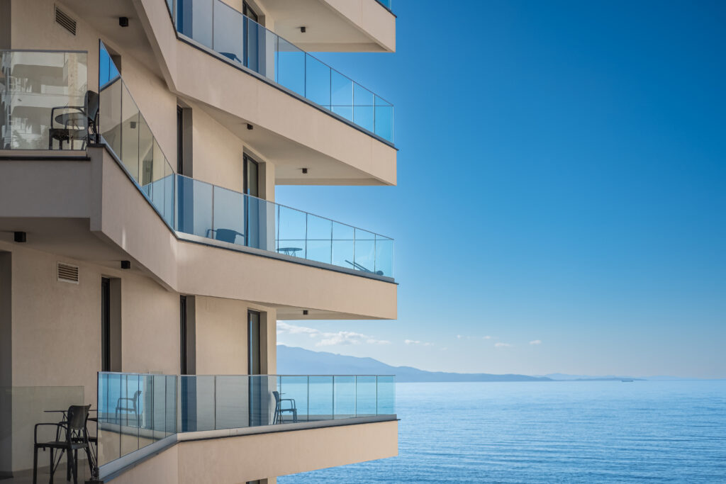 Modern apartment building on blue sky and sea background. Beautiful Architecture detail building with balconies